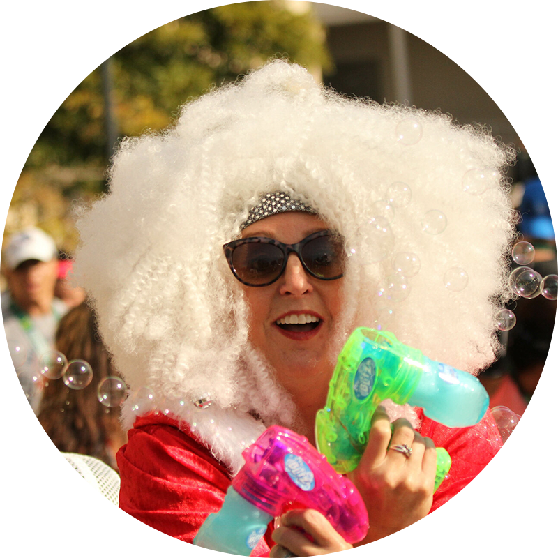Performer in a white wig and bubble guns