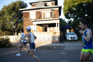 half marathon runners passing residential home in mile one of the berkeley mile-by-mile series