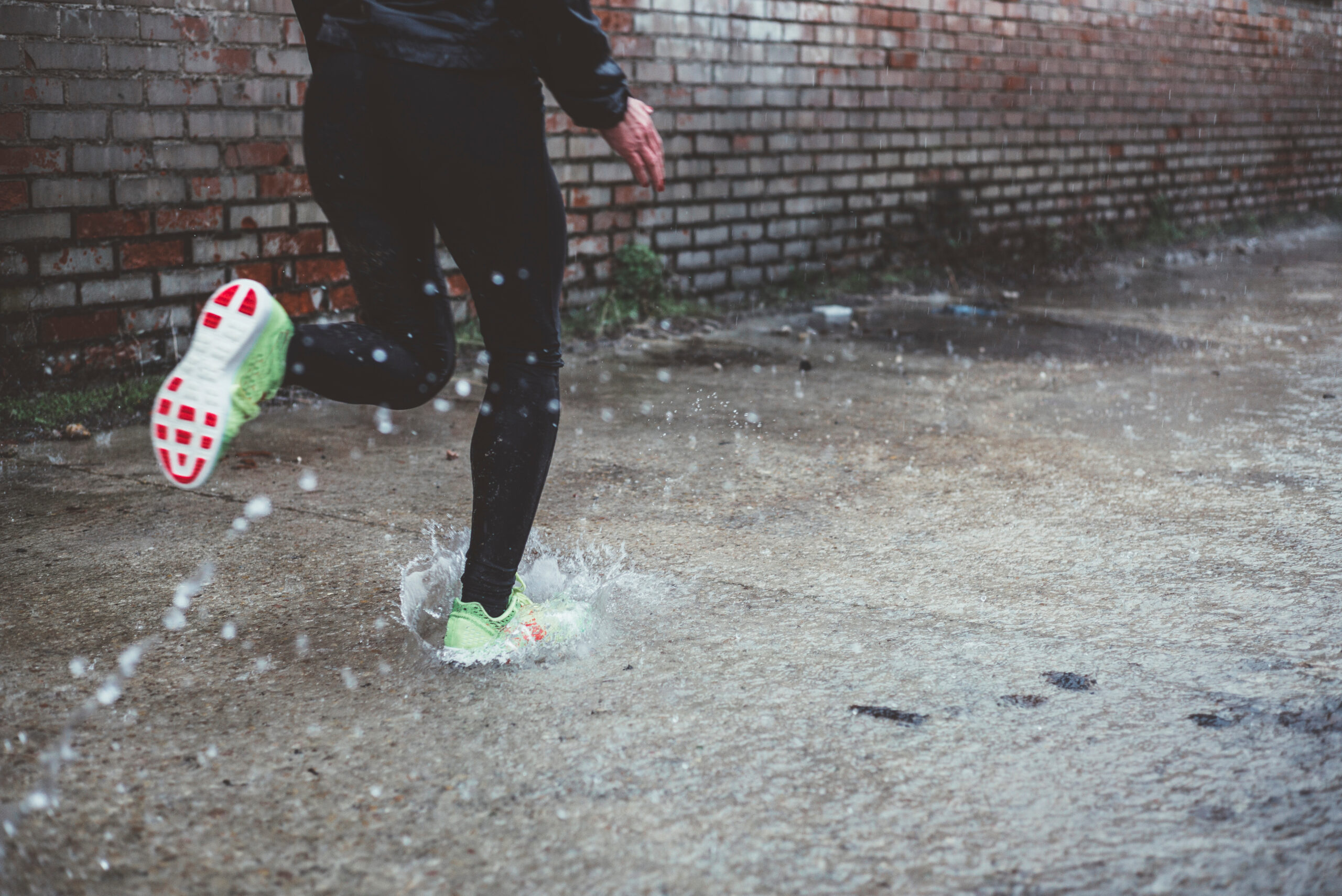 A woman runs on a street wearing cushioned shoes to help he trainsition from trail to road