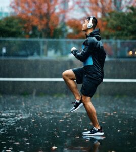 A man doing warm-ups for running in the rain
