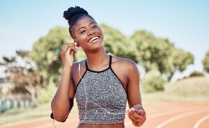 A smiling Black woman running with music