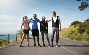 Members of a running club are smiling and chatting as they take a break in the middle of their run