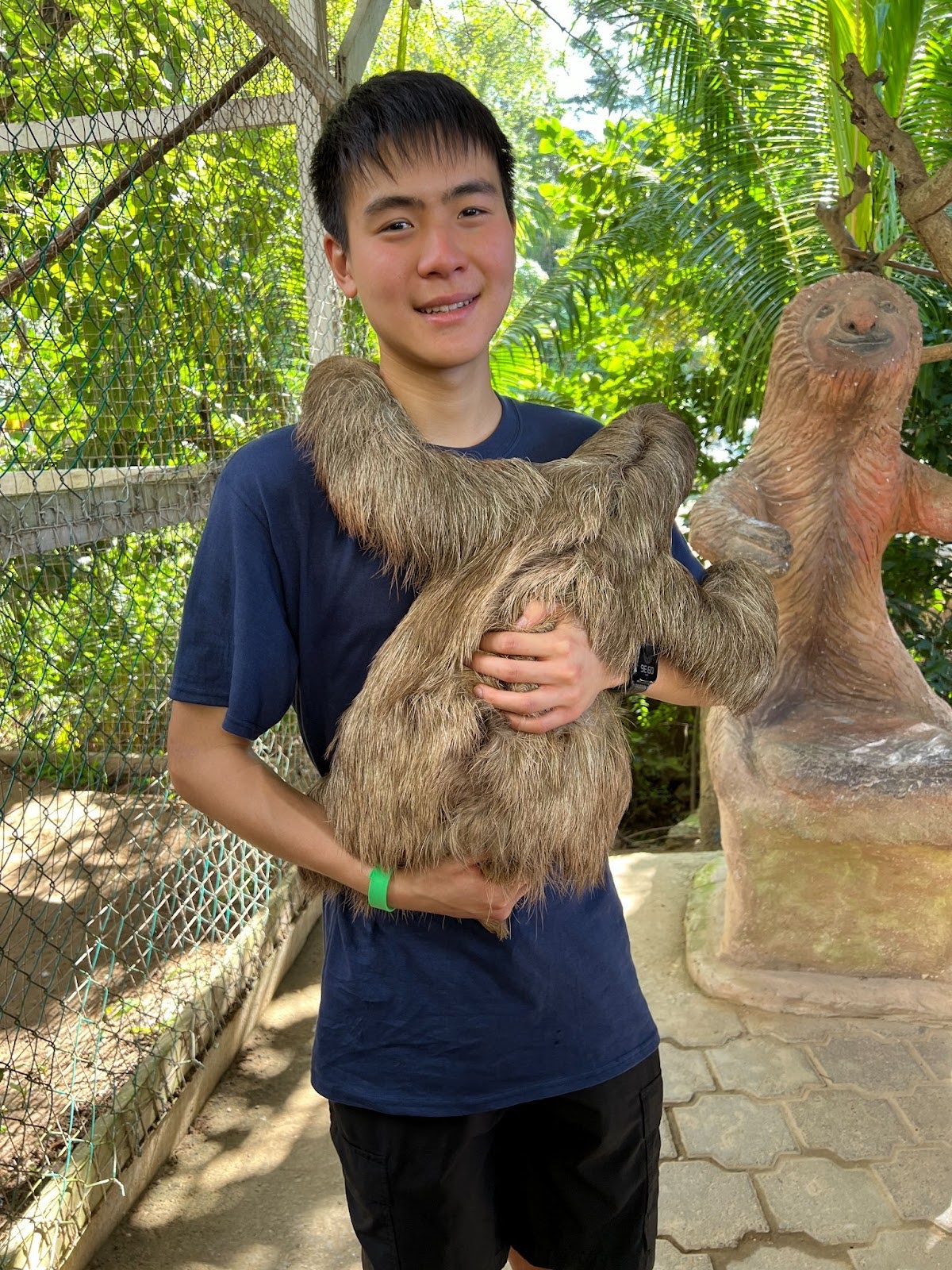 Christopher Lee of Cal Running Club holding a sloth and smiling at the camera
