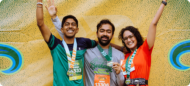 Group of runners with medals and arms raised
