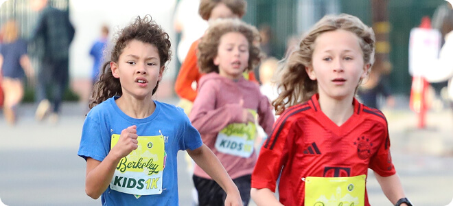 Three children running wearing race bibs